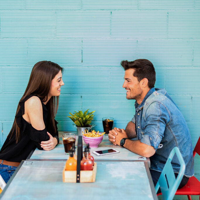 Happy young couple seating in a restaurant